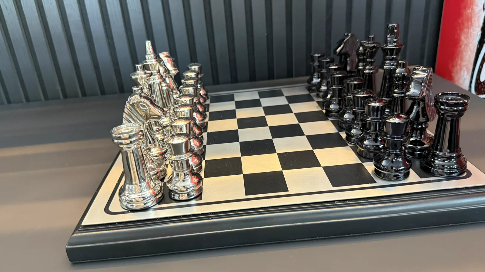 Schachbrett mit silbernen und schwarzen Figuren, aufgebaut auf einem Tisch